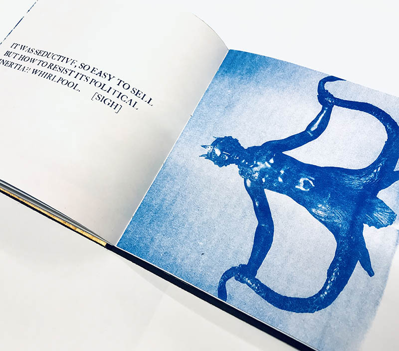 An open book with text printed on the left side and a vibrant blue illustration on the right side