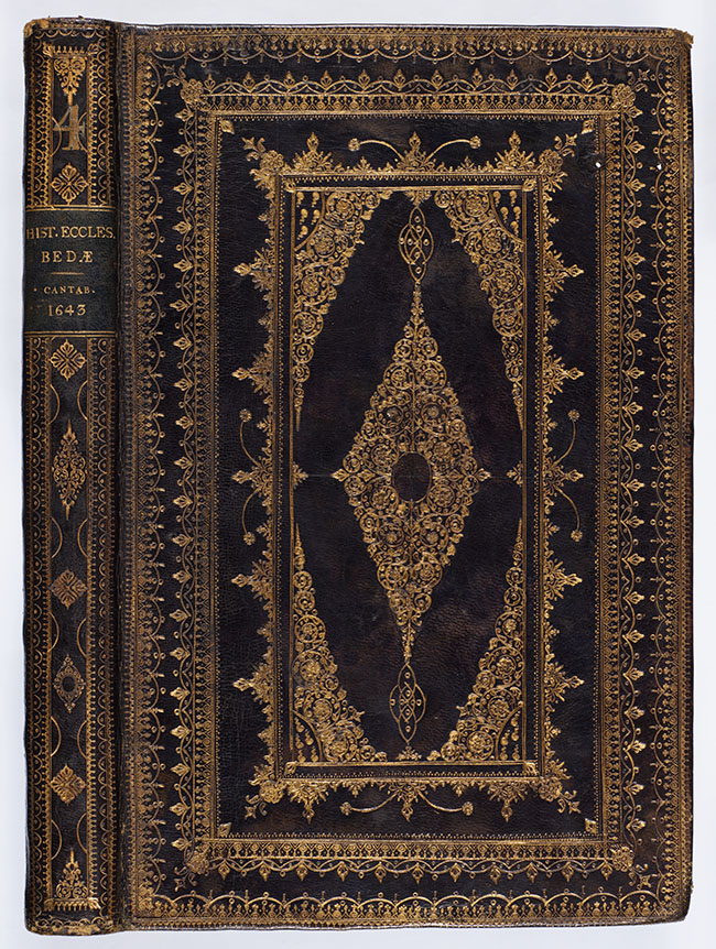 A bookbinding of the works of Bede made from black leather with elaborate gold designs