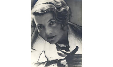 A photograph of a young woman looking directly at the camera