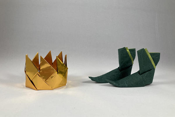 A gold crown to the left and a pair of green boots to the right - both made from paper
