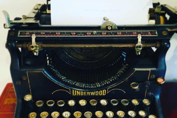An antique Underwood typewriter loaded with a blank sheet  of paper 