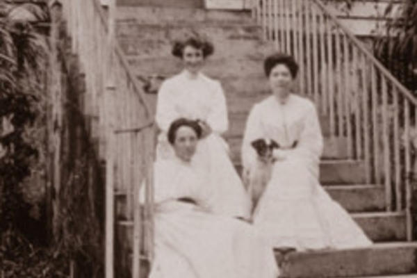 Black-and-white photograph of three women sitting on steps