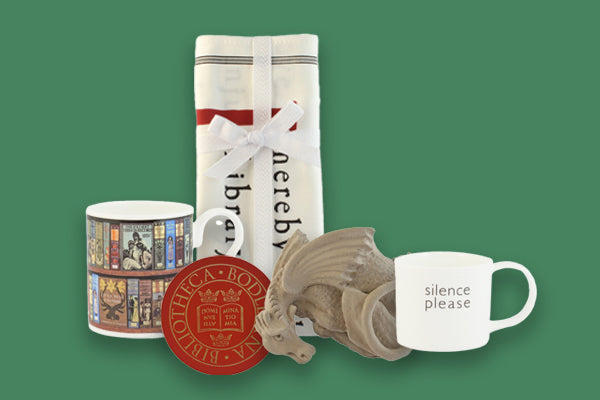 Mugs, place mats and a dragon sculpture against a green background