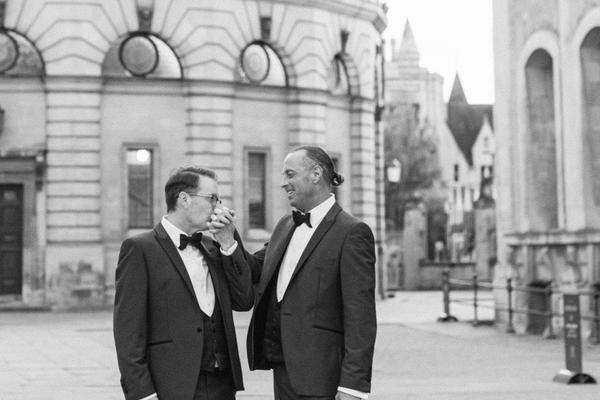 A black and white photo of two grooms in the quad outside the Bodleian Library