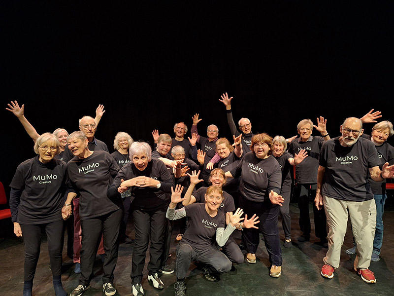 A group of older people in dynamic poses about to perform