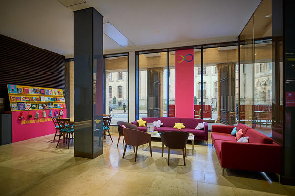 A space showing two sofas, two padded chairs and a bookshelf