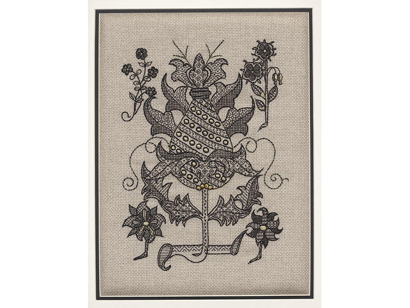 A decorative crest embroidered in black on a grey canvas