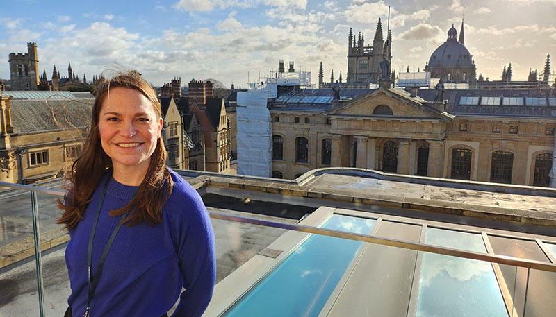 A woman stands on the roof terrace at the Weston Library - behind here is the Oxford skyline of spires