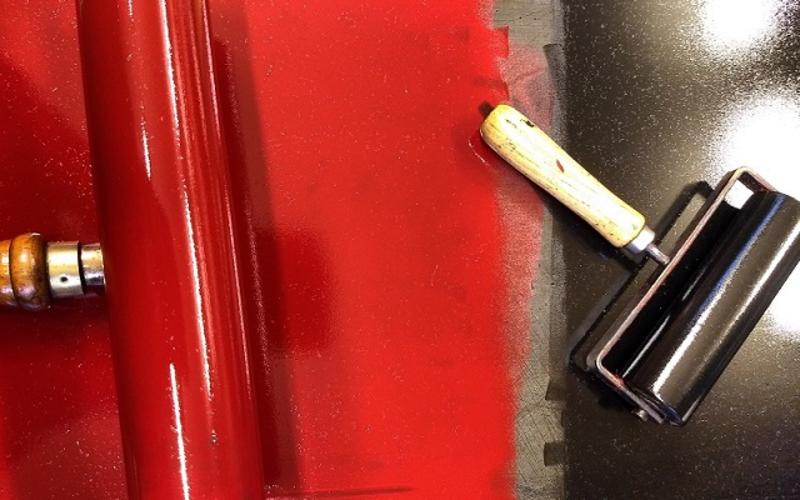 Image of a large roller in red ink and a smaller roller in black ink