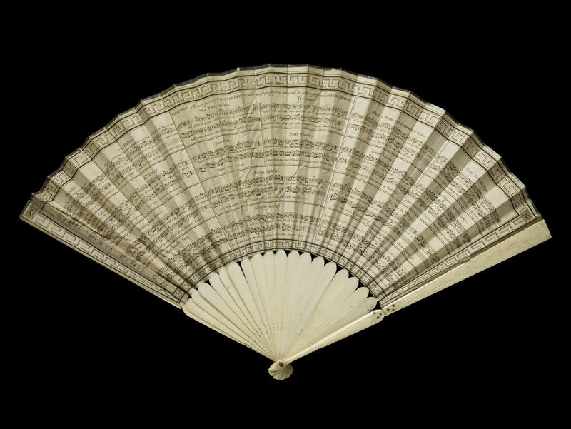 A white hand-held fan with music notations across it