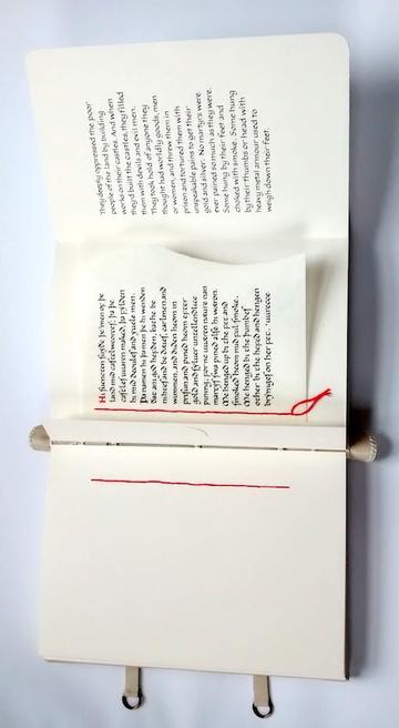 A foldout book with stitched binding and red thread detail