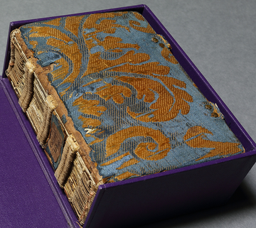 Image of a book covered in gold and blue velvety material