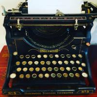 An antique Underwood typewriter loaded with a blank sheet  of paper 